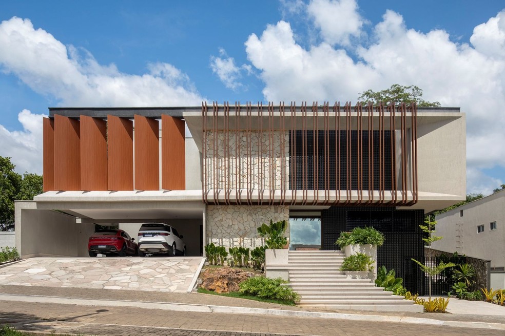 A fachada da casa conta com um eixo central de pedras moledo, da Margran, em tom claro, que além de valorizar a estética contribui para a reflexão solar — Foto: Denilson Machado/MCA Estúdio/Divulgação | Projeto da arquiteta Vangii Guerra