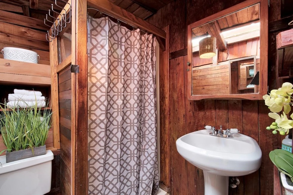 A casa flutuante tem um banheiro completo todo revestido de madeira — Foto: Realtor / Reprodução