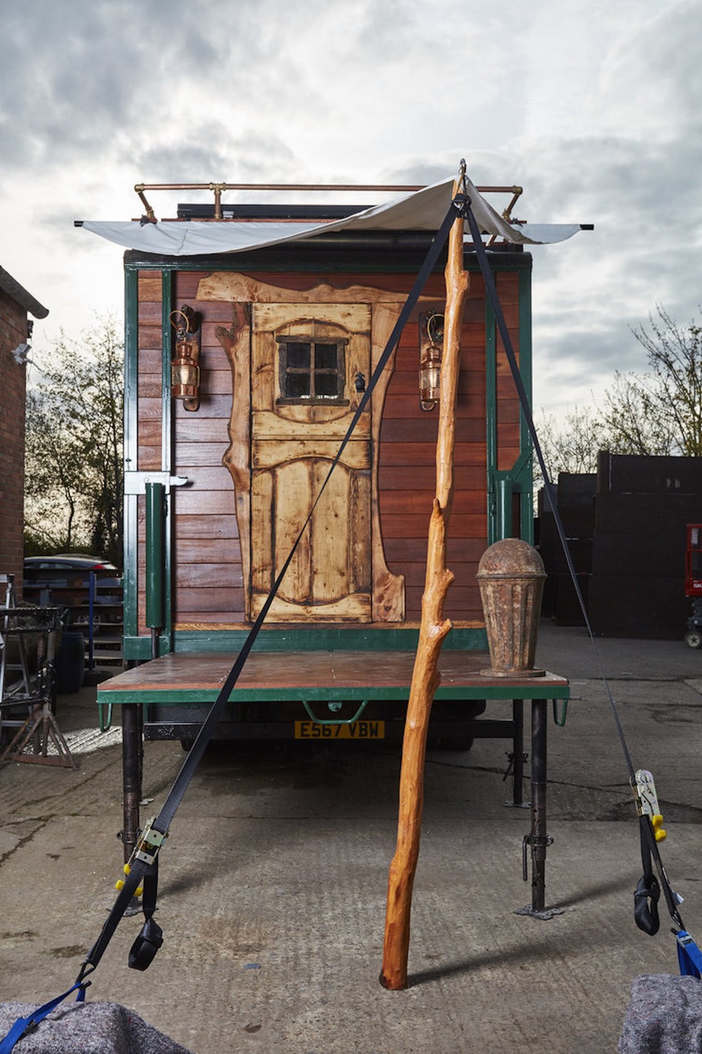 A entrada da casa feita em um caminhão de cavalos é rústica e toda trabalhada na madeira — Foto: House Box / Reprodução