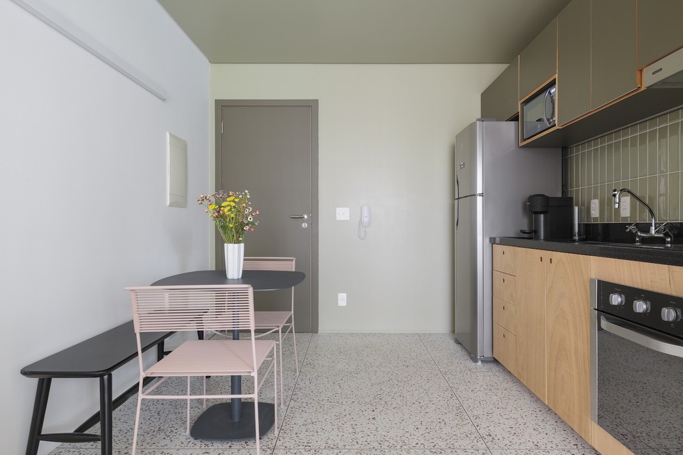 COZINHA | O cômodo fica na entrada do apartamento e traz uma pequena mesa com banco e cadeiras. Piso da Granitorre — Foto: Felco / Divulgação
