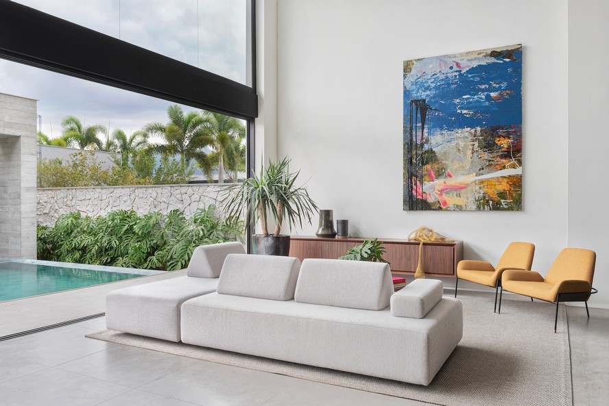 SALA DE ESTAR | O sofá Way, da Líder Interiores, cria duas áreas diferentes no estar. A obra de arte na parede traz o ponto focal de cor