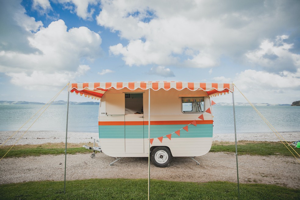 A van vintage fica estacionada à beira-mar em área de grande beleza natural da Nova Zelândia — Foto: Airbnb / Divulgação