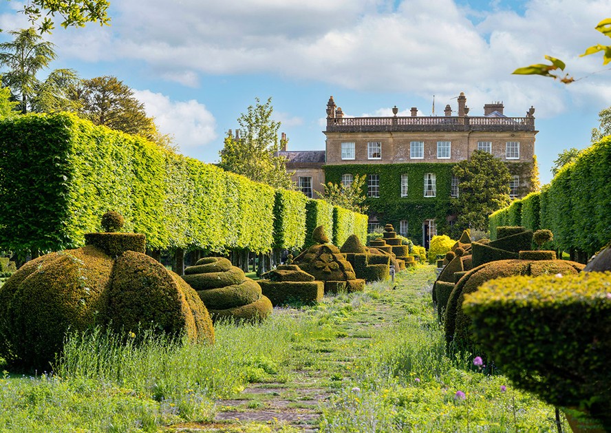 O jardim de topiarias exóticas leva à casa construída em estilo neoclássico do século 18
