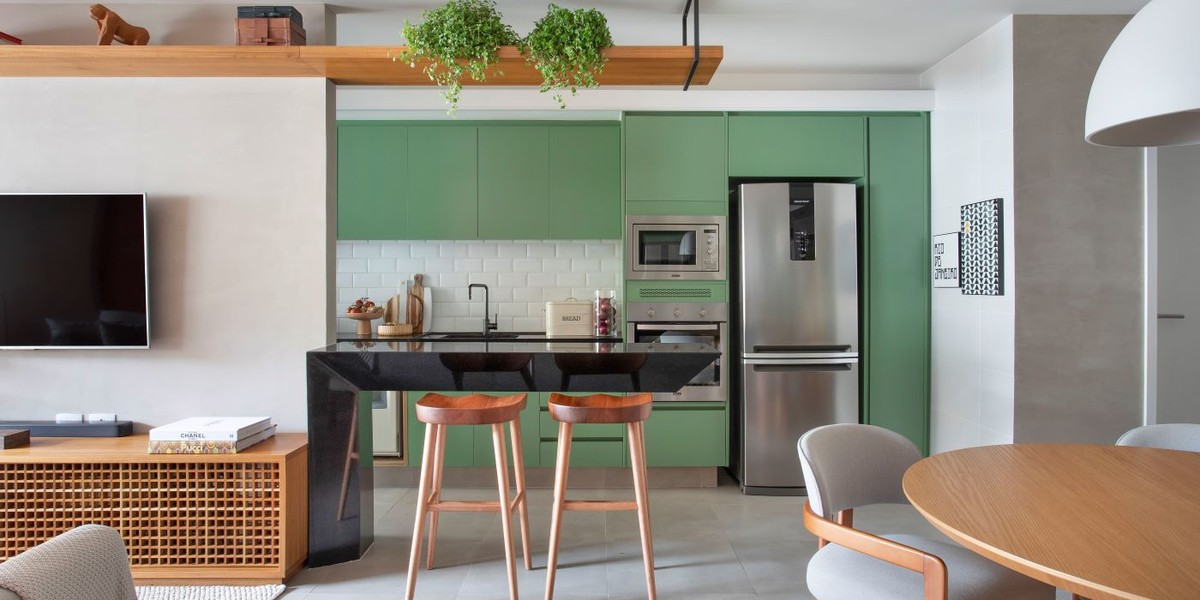 Cozinha verde e integrada é o ponto alto deste apartamento de 78 m²