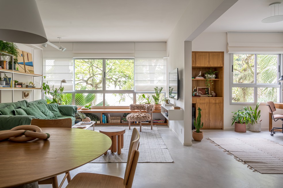 Apartamento com base neutra tem muita madeira e plantas na decoração