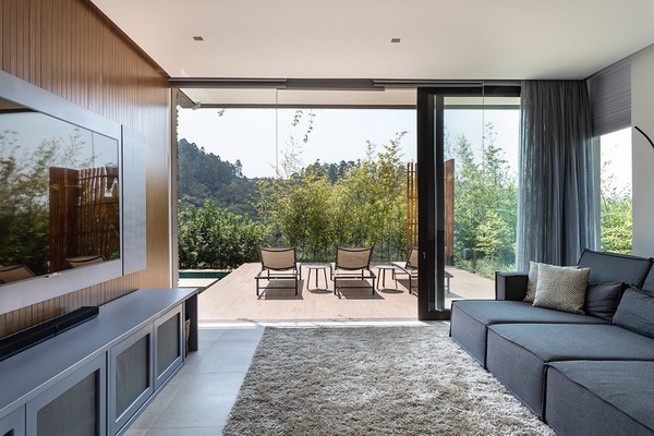 Casa contemporânea é envolvida pela natureza e se integra à paisagem