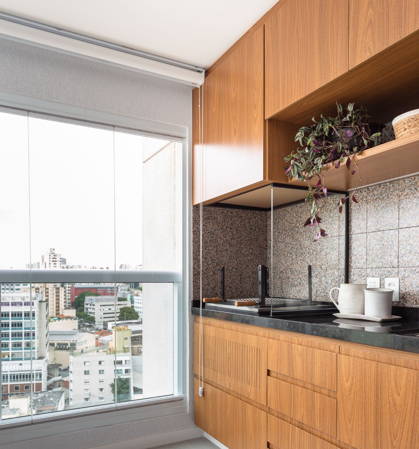 Em torno da churrasqueira, as arquitetas do Studio Tangram criaram um armário e pensaram na ventilação na porta para vazar o calor do braseiro — Foto: Studio Tangram / Estudio São Paulo