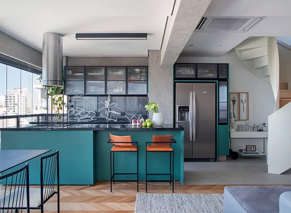 O tríplex projetado pelo Studio Ro+Ca tem cozinha aberta com armários verdes-azulados e detalhes em tons neutros — Foto: Denilson Machado / MCA Estúdio / Divulgação
