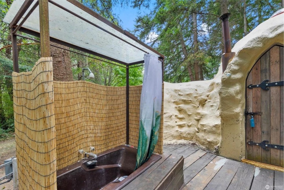 O chuveiro e a banheira ficam do lado de fora da casa, em cima de um tablado de madeira — Foto: North West / Reprodução
