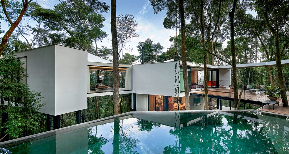 Casa suspensa na natureza tem fechamento de vidro para apreciar as árvores. Projeto do Tetro Arquitetura — Foto: Jomar Bragança / Divulgação
