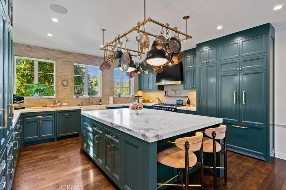 A cozinha luxuosa tem armários na cor azul-petróleo — Foto: Coldwell Banker / Reprodução