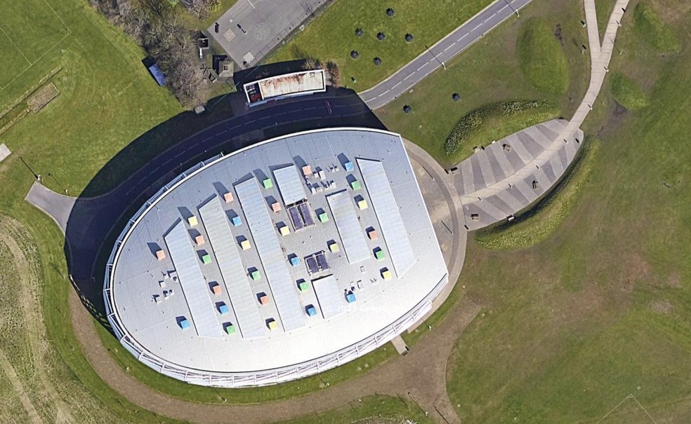 O formato oval coloca as salas de aula em torno do ginásio para incentivar a prática esportiva — Foto: Google Street View / Reprodução