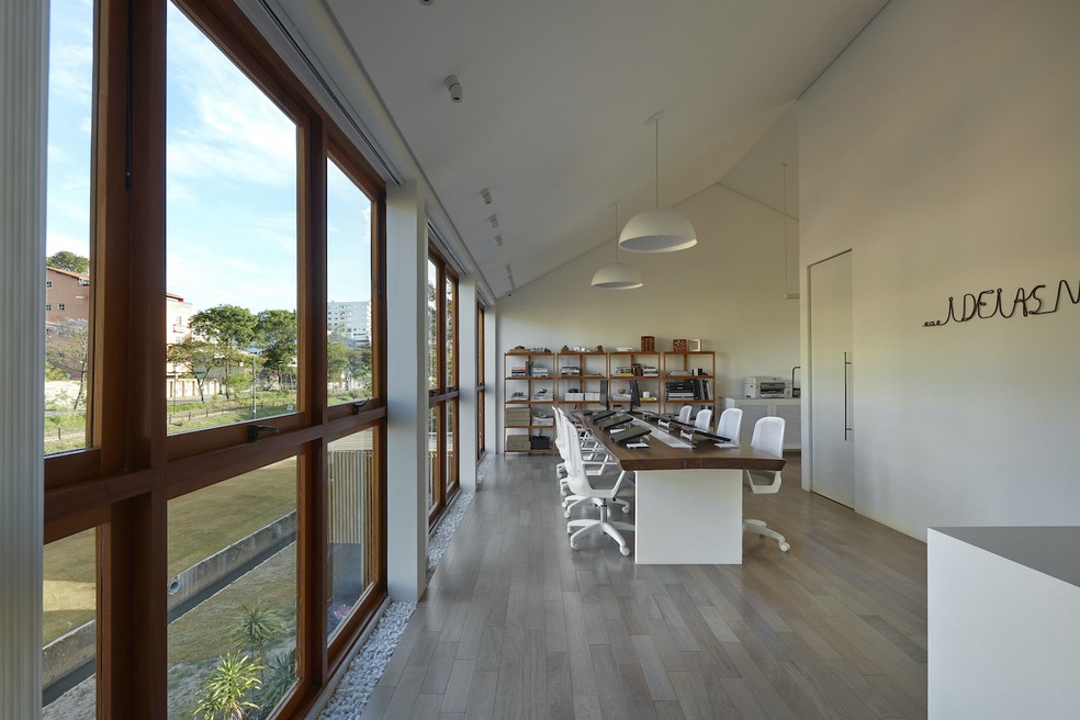 ESCRITÓRIO | Os amplos janelões oferecem uma vista livre do entorno para as equipes que trabalham no salão principal do escritório de arquitetura — Foto: Jomar Bragança / Divulgação