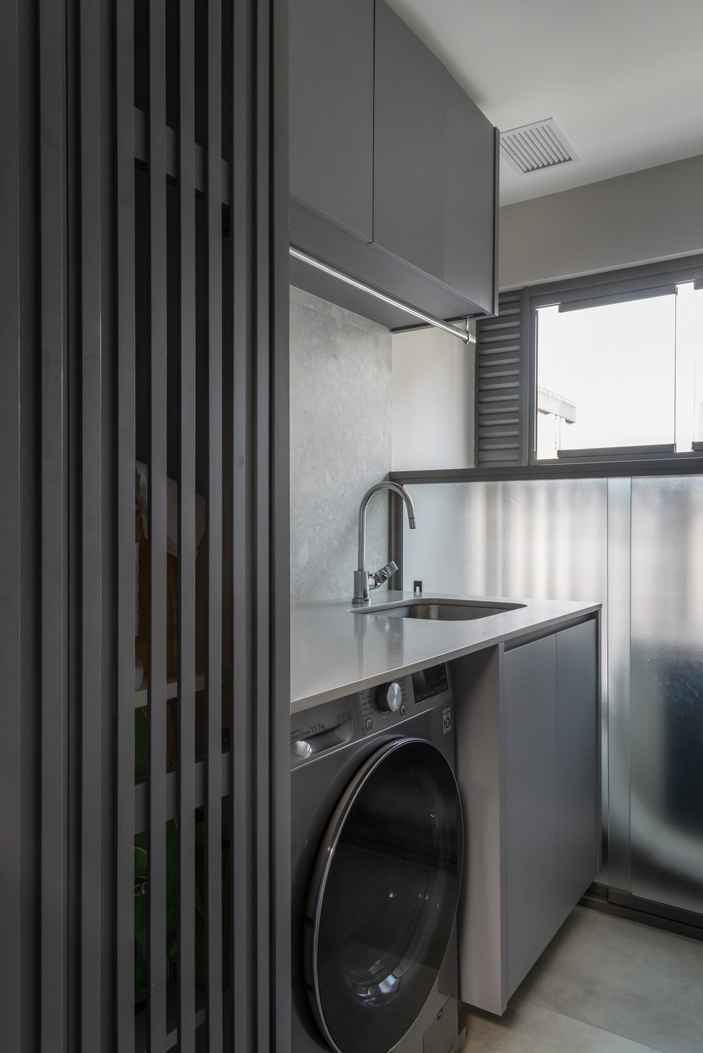 LAVANDERIA | A lavanderia segue o mesmo tom da cozinha, criando unidade entre os ambientes — Foto: Evelyn Müller / Divulgação