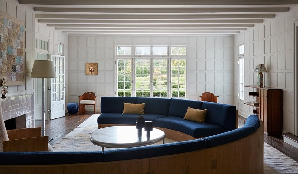 A sala de estar tem uma lareira, um sofá espaçoso e mais janelas de vidro — Foto: Stephen Kent Johnson / OTTO / Reprodução
