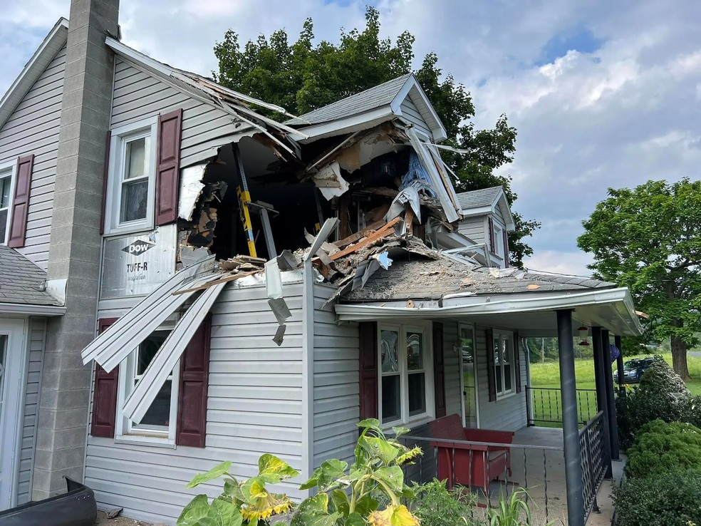 Um enorme buraco no canto superior da casa foi deixado quando o carro foi removido — Foto: Junction Fire Company / Divulgação