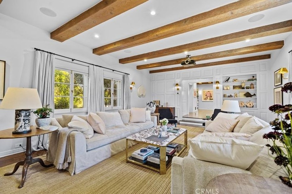 A sala e estar tem sofás brancos grandes e espaçosos — Foto: Coldwell Banker / Reprodução