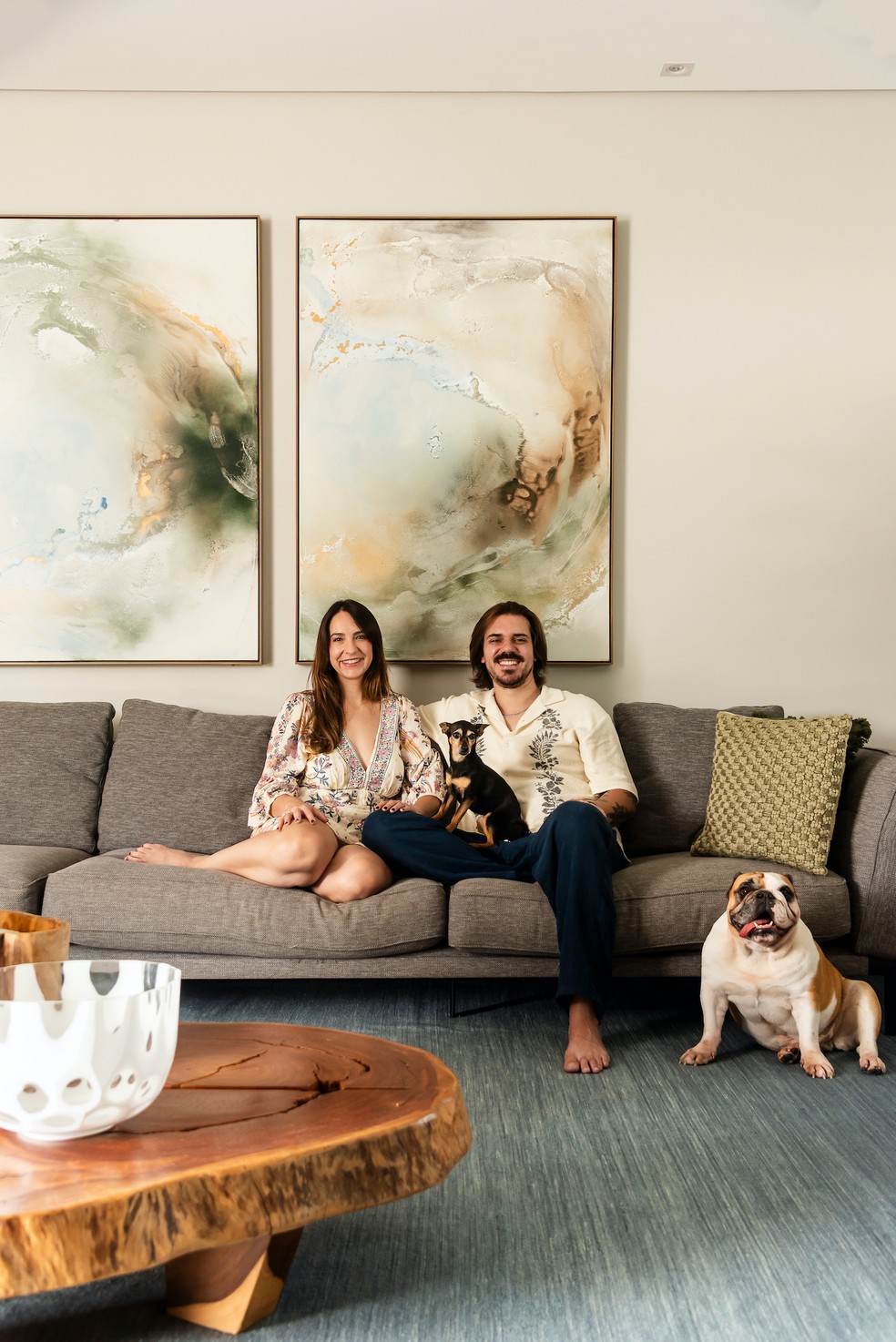 RETRATO | Leonardo e Evelin sentados no sofá, do acervo pessoal, na sala de estar com as celebridades pets Madalena e Bica. Quadros da MJ Home — Foto: Wesley Diego/Editora Globo