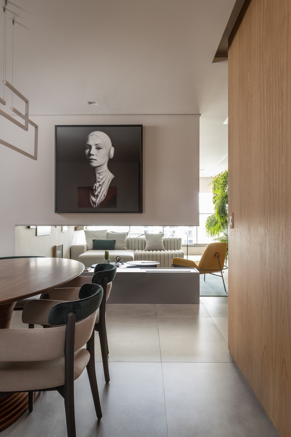SALA DE JANTAR | As obras de arte estão presentes em todo o apartamento. Mesa de jantar é de Fernando Jaeger e sofá, ao fundo, da Lider Interiores — Foto: Evelyn Müller / Divulgação