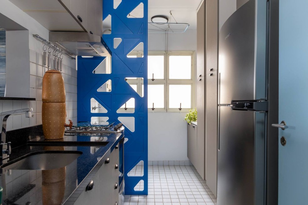 COZINHA | O elemento vazado, da Zebra.design, delimita a lavanderia. A bancada da cozinha foi trocada, assim como as portas e os puxadores dos armários — Foto: Leila Viegas / Divulgação