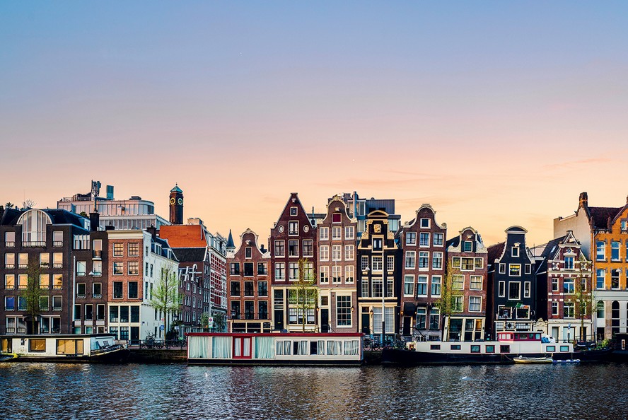 As casas estreitas, inclinadas e ornamentadas são um dos principais símbolos arquitetônicos de Amsterdam. O encurvamento dos imóveis é provocado pelo solo úmido, que torna as antigas fundações instáveis com o tempo