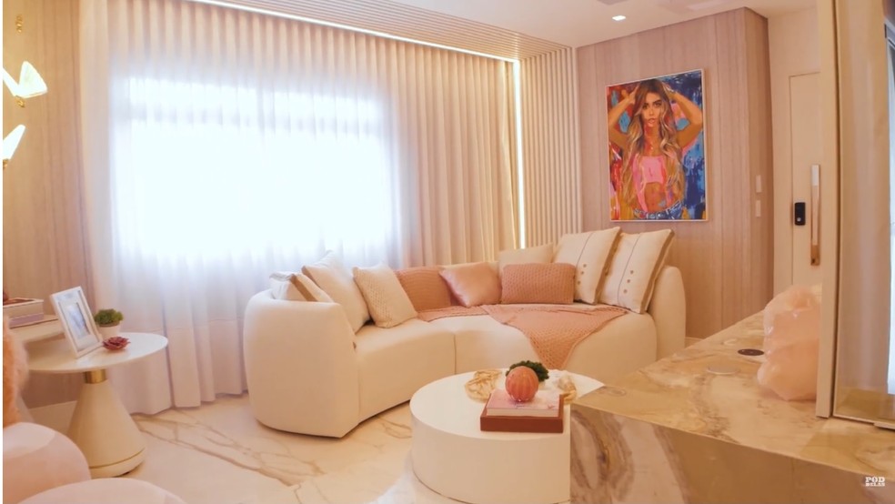 A sala de estar tem um quadro da influenciadora em uma das paredes — Foto: Youtube / Reprodução