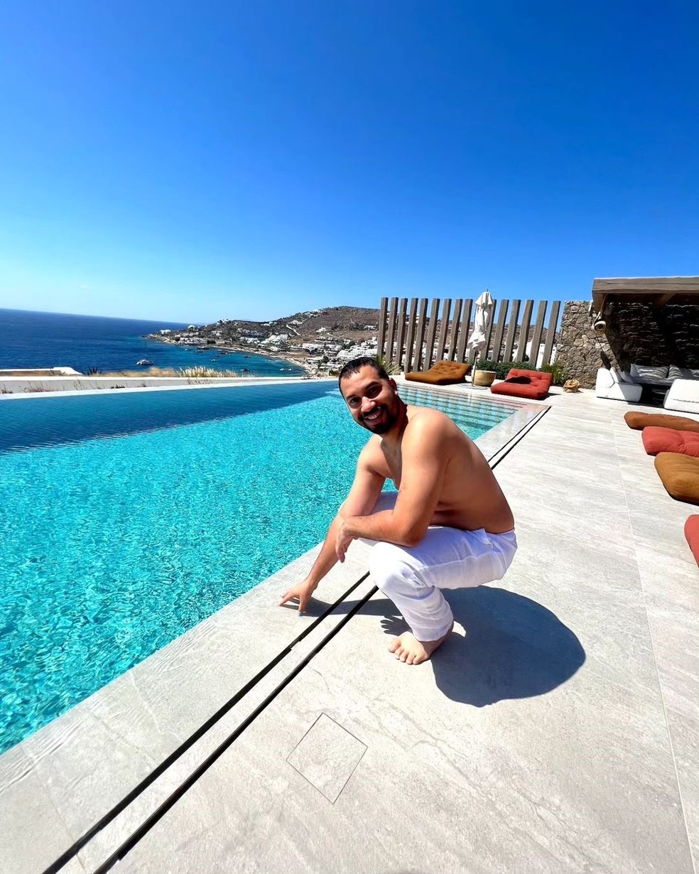 Gil do Vigor posa ao lado da piscina de borda infinita da hospedagem luxuosa — Foto: Instagram @gildovigor / Reprodução