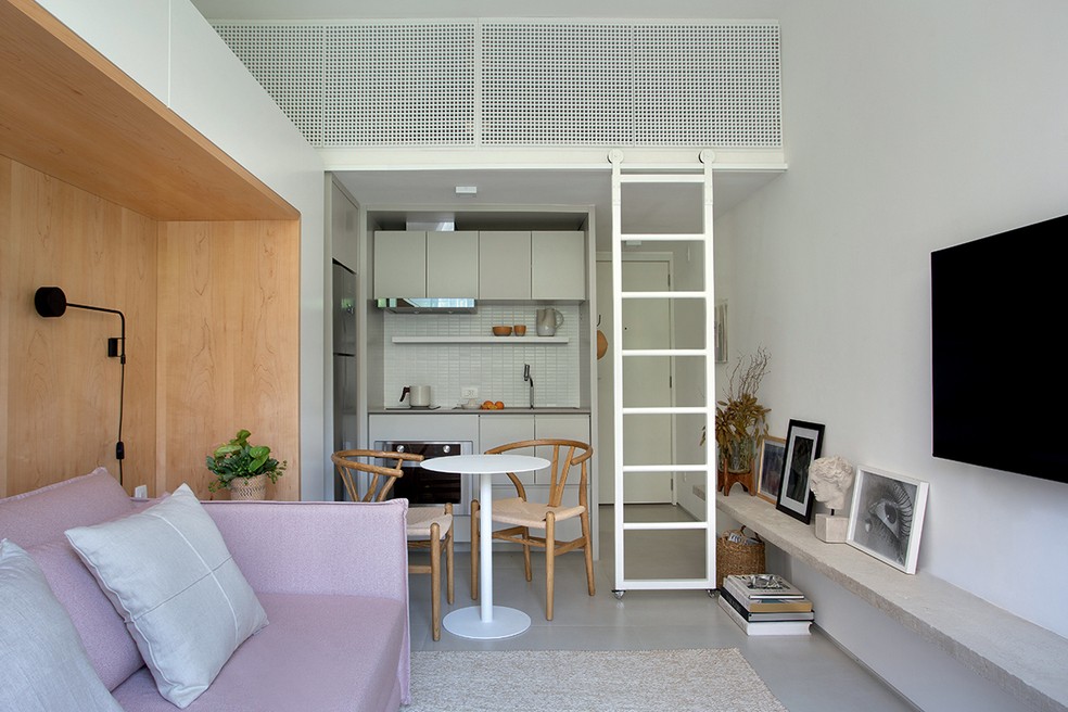 No projeto do PKB Arquitetura, a sala de estar funciona como quarto graças ao sofá-cama rosa-claro — Foto: Foto: Denilson Machado / MCA Estúdio / Divulgação