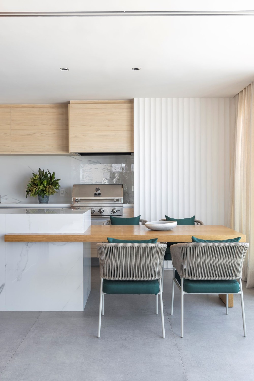 Base neutra e espaços integrados criam visual atemporal em apartamento