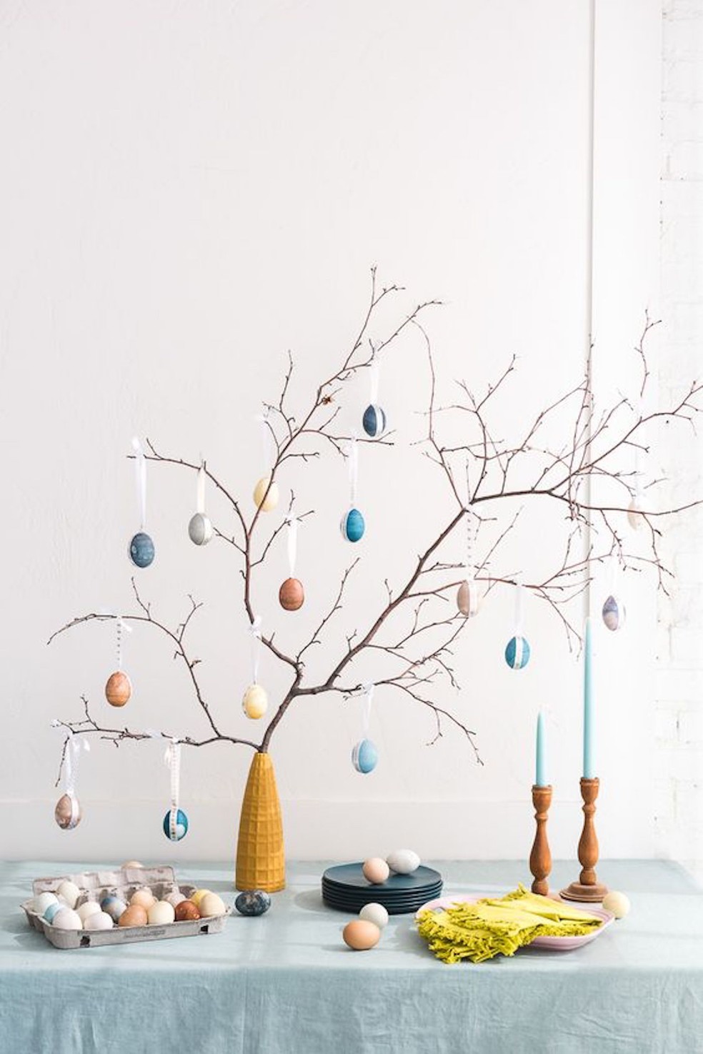Galhos secos de árvore com ovos pendurados podem servir de decoração para a mesa de Páscoa — Foto: Pinterest / The House That Lars Built / Reprodução