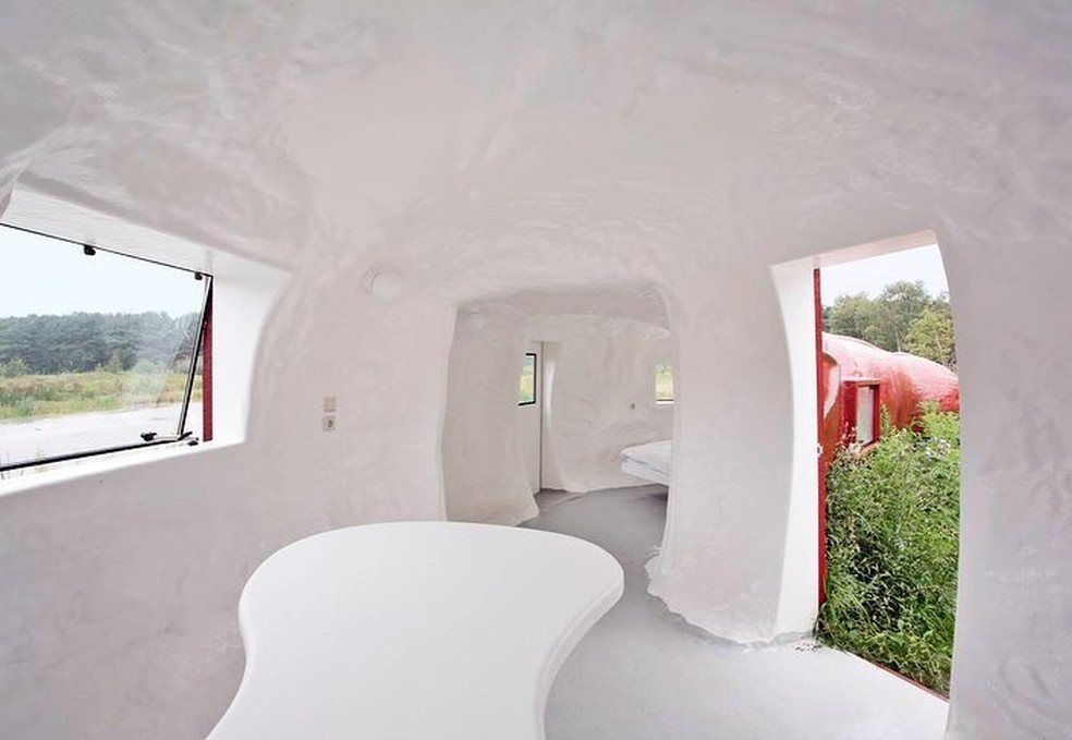 A casa tem uma cama de casal, uma mesa e um banheiro com chuveiro — Foto: Instagram/@atelier_van_lieshout/Reprodução