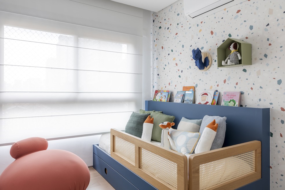  Para o quarto do filho, o projeto do escritório AS Design e Arquitetura propôs um papel de parede que lembra granilite bem alegre e móveis de cores fortes — Foto: Rafael Renzo / Divulgação