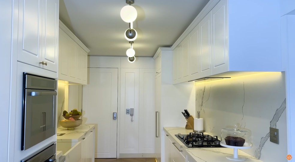 A cozinha é otimizada e tem cores claras. Armários da Dellano Atelier — Foto: Youtube / Reprodução