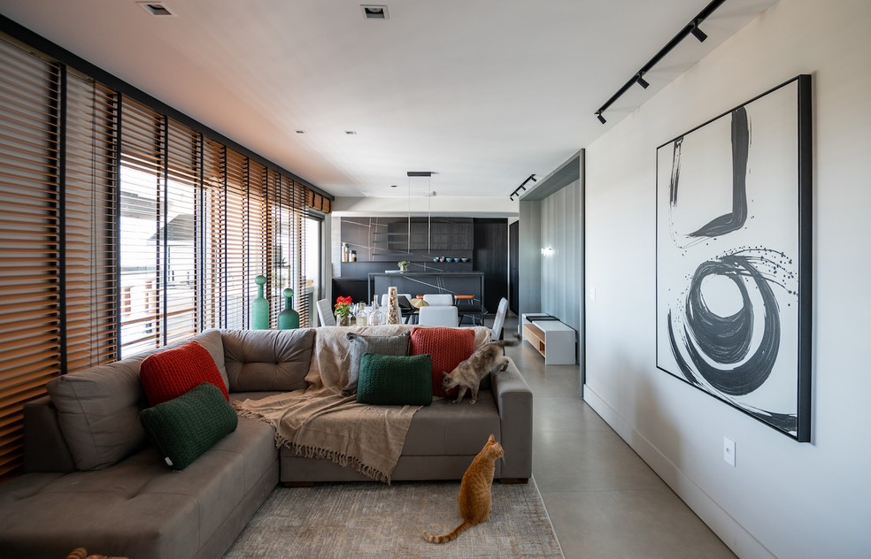 O sofá em L delimita ambientes e dá privacidade à sala de estar. Projeto do escritório Sotaque Arquitetura — Foto: Fávaro Júnior / Divulgação