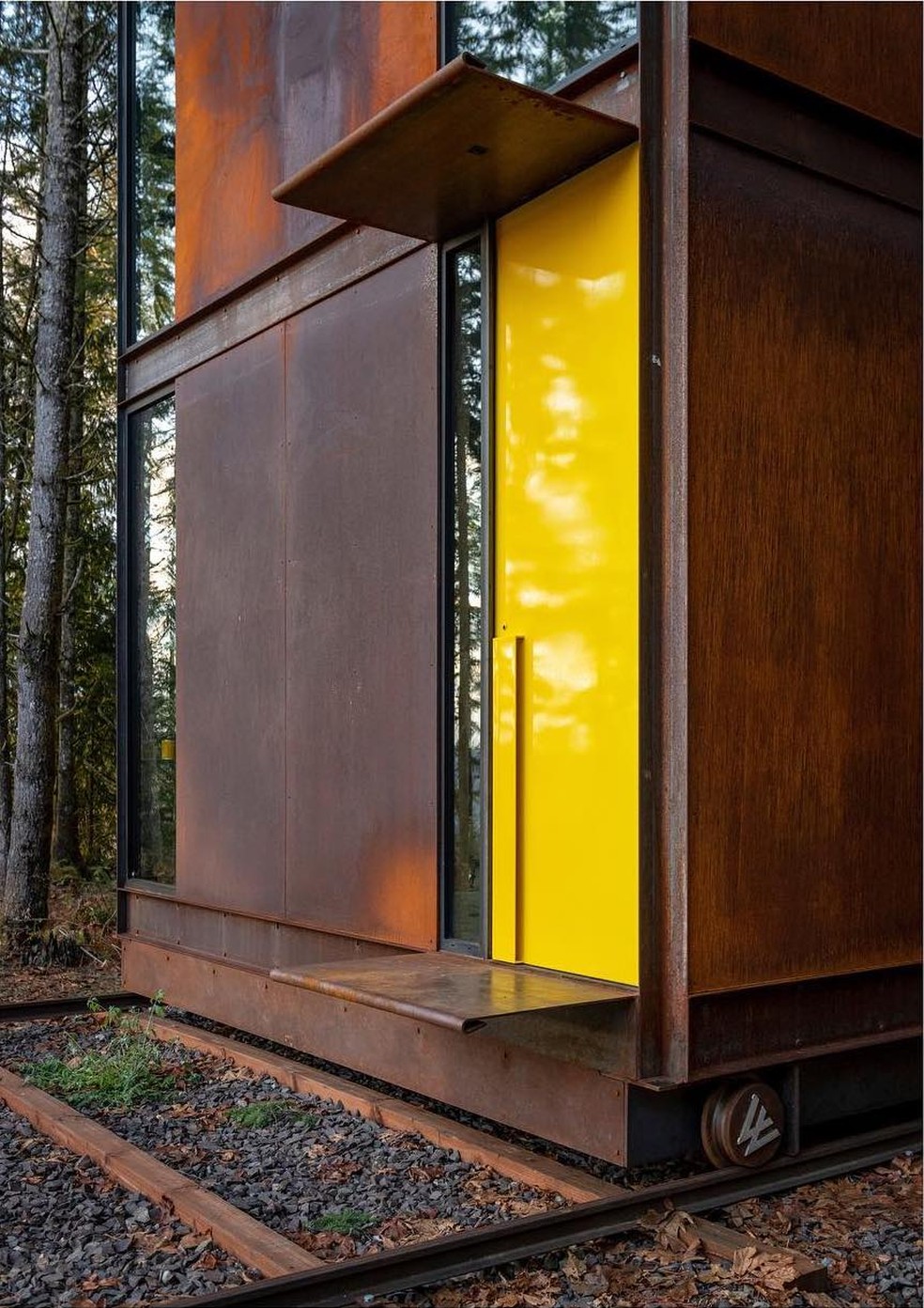 A porta amarela se destaca na estrutura feita de madeira — Foto: Instagram / @olsonkundig / Reprodução