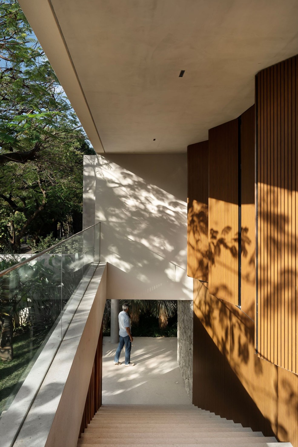 Casa em aclive é marcada por integração com o jardim e vista para a rua