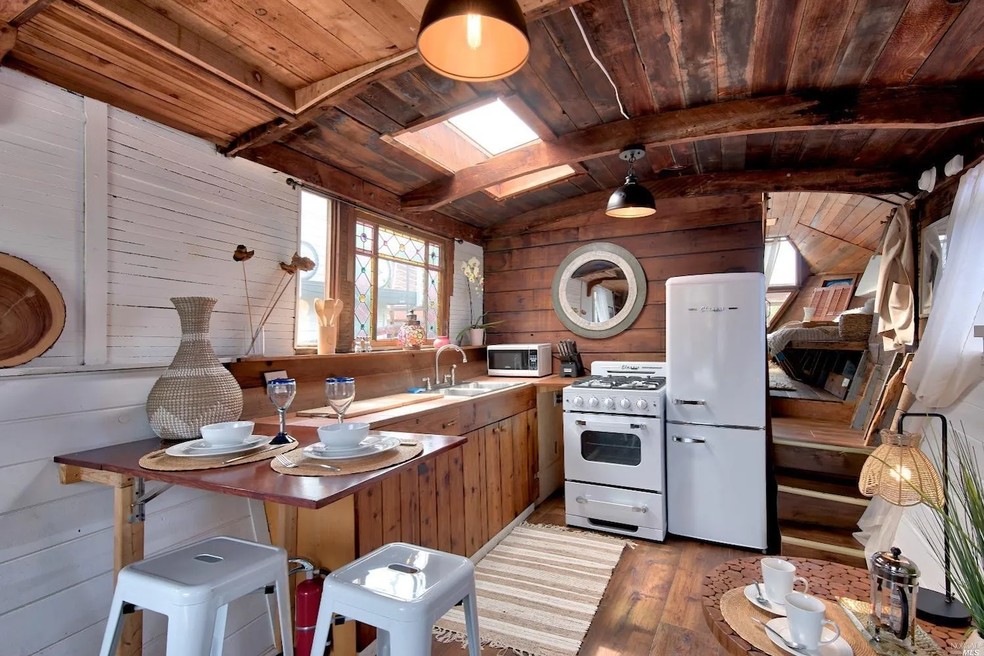 A casa flutuante possui cozinha integrada e uma pequena área de refeições — Foto: Realtor / Reprodução