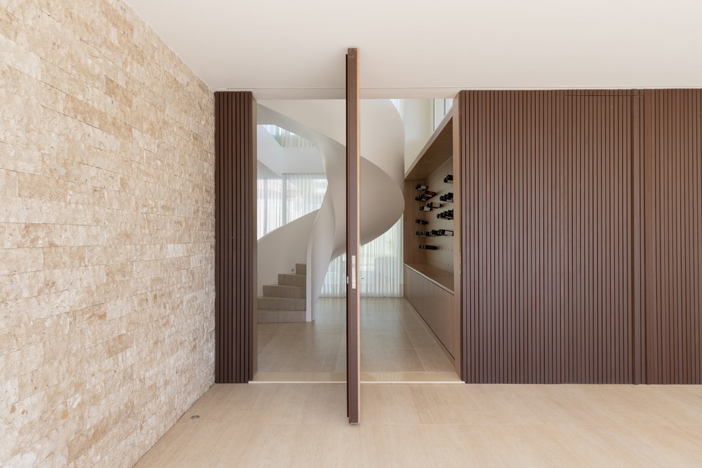 ESCADA | A escada é um elemento de design dentro do estar. Iluminação da Light Design — Foto: Júlia Tótoli / Divulgação