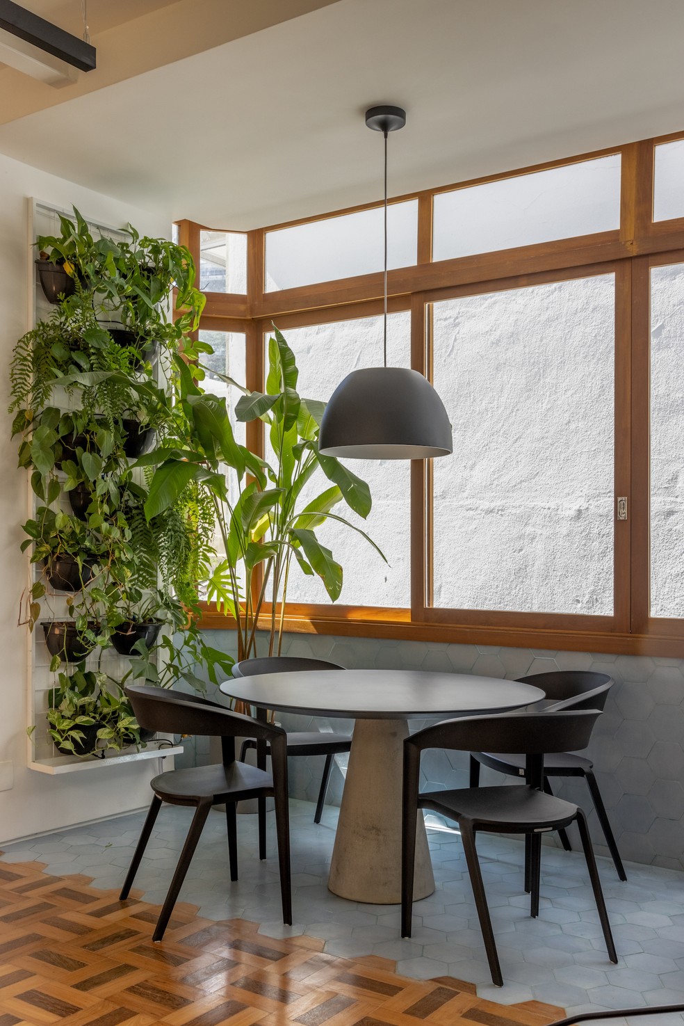 SALA DE JANTAR | A parede de plantas garante que os moradores tenham contato com a natureza mesmo na área social — Foto: André Nazareth / Divulgação