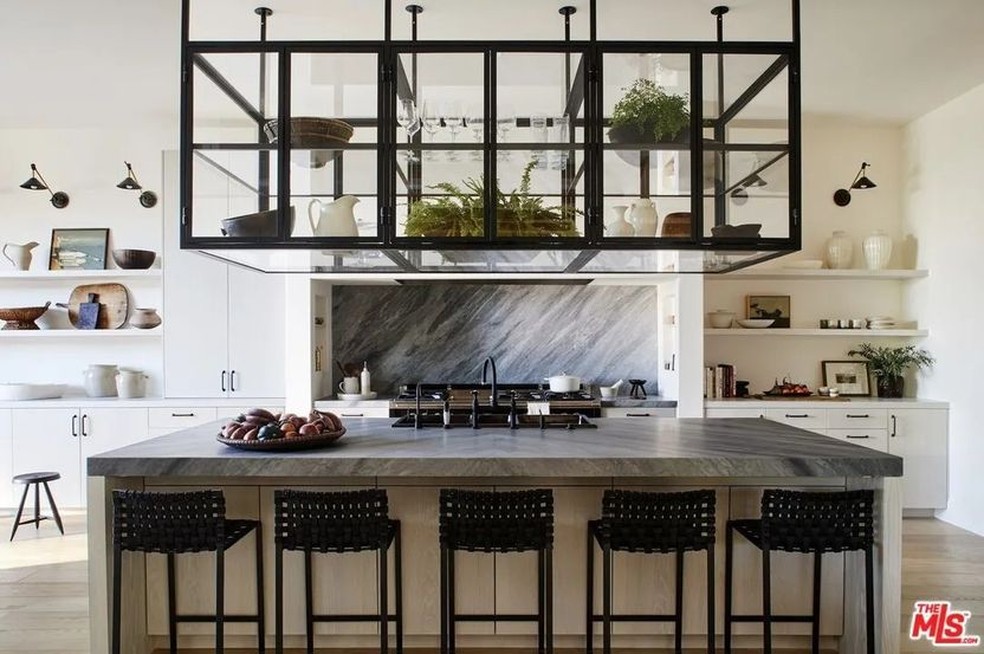 A cozinha tem uma bancada grande de mármore com espaço para cinco pessoas — Foto: Realtor.com / Reprodução