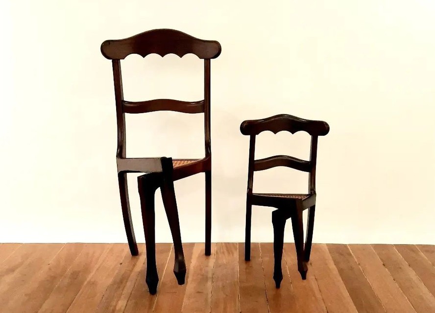 A Cadeira de Pernas Cruzadas no formato tradicional e na versão de menor tamanho (fora de série e muito rara); a peça é feita manualmente pelo artista Luiz Philippe Carneiro de Mendonça