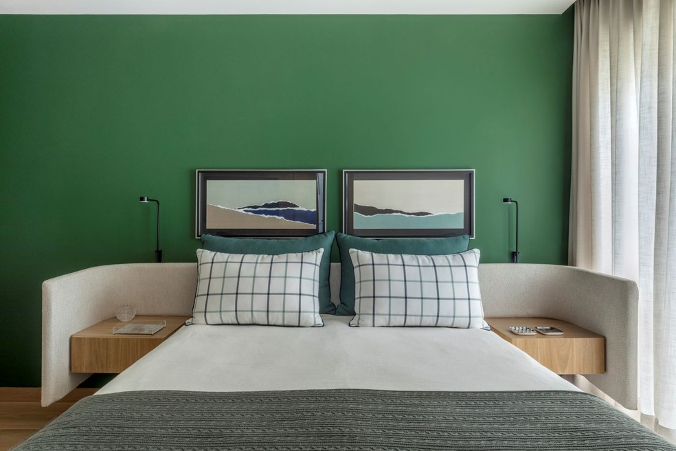 QUARTO DE HÓSPEDES | No cômodo verde, a cabeceira curva desenhada pelo escritório "abraça" as mesas laterais, executadas pela Casa Marista. A luminária da Dsgnselo, na Illuminato, foi adaptada ao desenho da marcenaria para criar uma solução exclusiva para o ambiente — Foto: Edgar Cesar/Divulgação