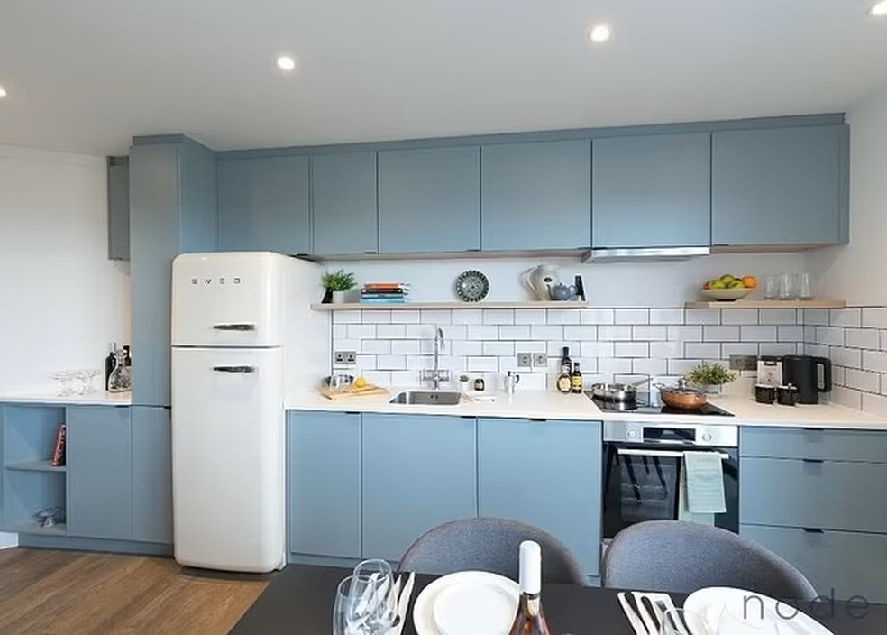 A cozinha do apartamento é integrada e tem móveis na cor azul — Foto: Node / DailyMail / Reprodução