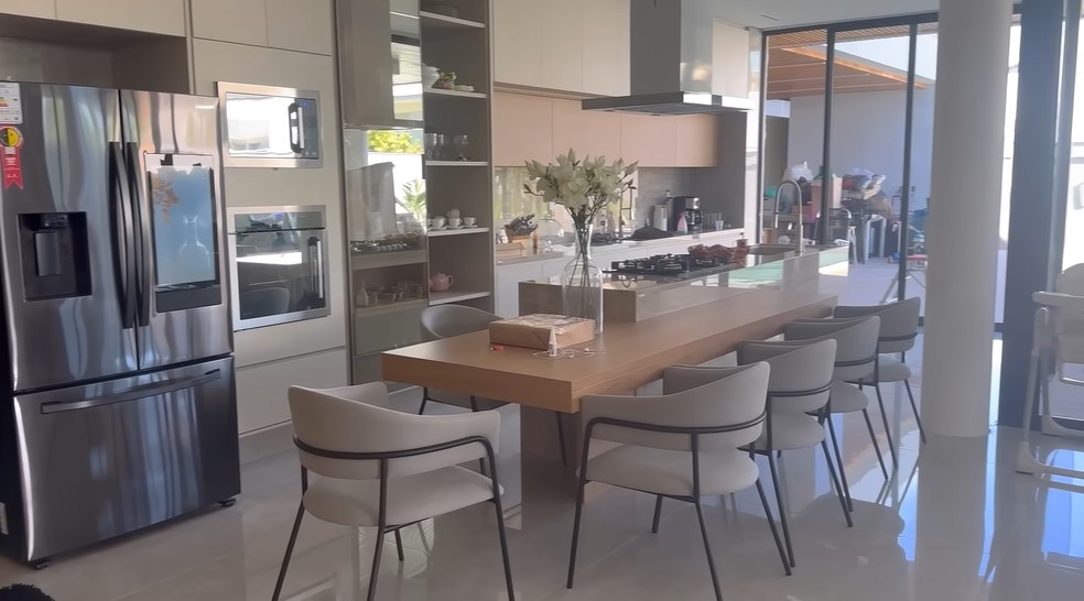 A cozinha é integrada com a mesa de jantar, que tem espaço para 10 pessoas — Foto: Youtube / Reprodução