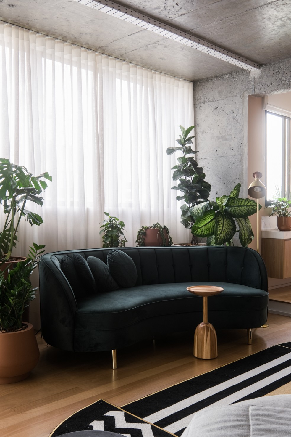 SALA DE ESTAR | O sofá verde já era dos moradores e foi incorporado na decoração.O paisagismo foi assinado pelo escritório Ciclo Natural — Foto: Julia Mota / Decoração