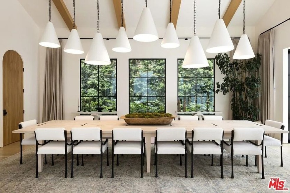 A sala de jantar tem uma mesa espaçosa com 14 cadeiras e diversos pendentes no teto — Foto: Realtor.com / Reprodução