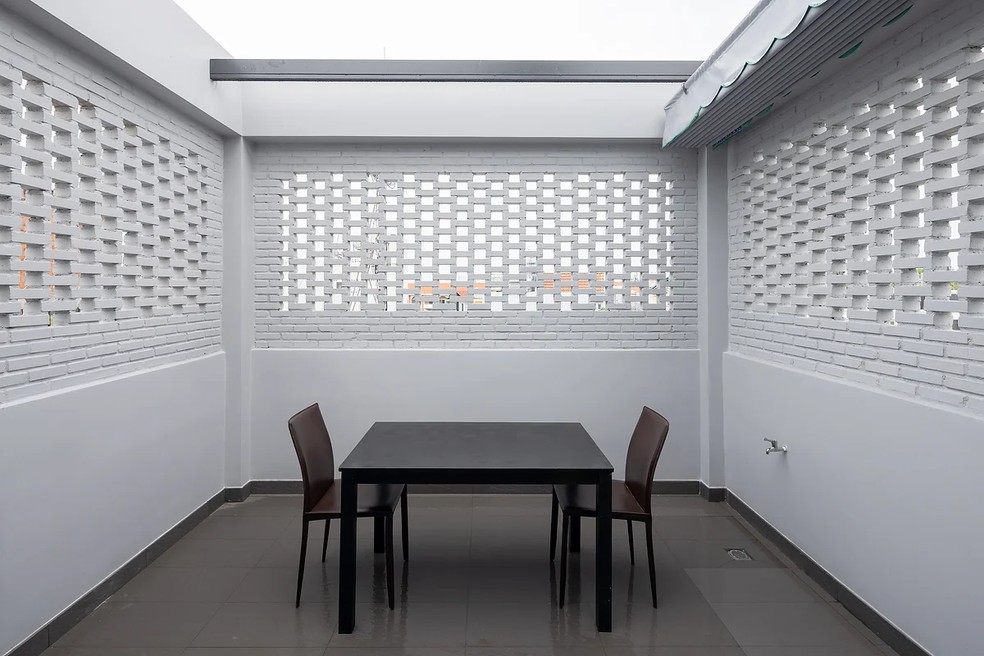 Na cobertura, há uma pequena área de jantar para refeições ao ar livre — Foto: Triệu Chiến / STD Design Studio / Reprodução
