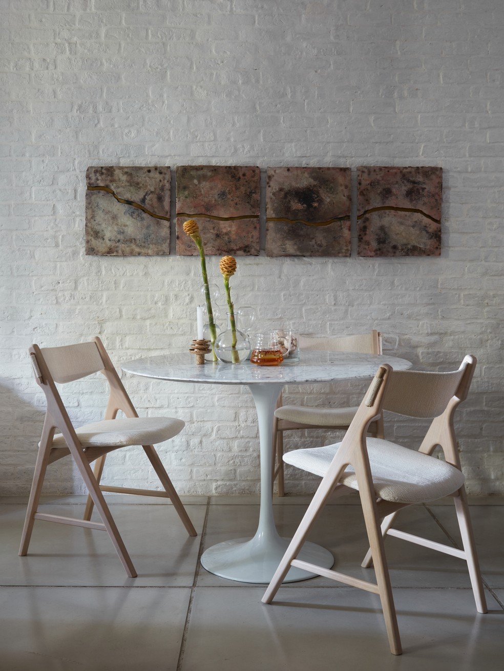 SALA DE JANTAR | A mesa de jantar Saarinen combina com a proposta de decoração do apê. Cadeiras foram garimpadas — Foto: Paula Chaffin / Divulgação