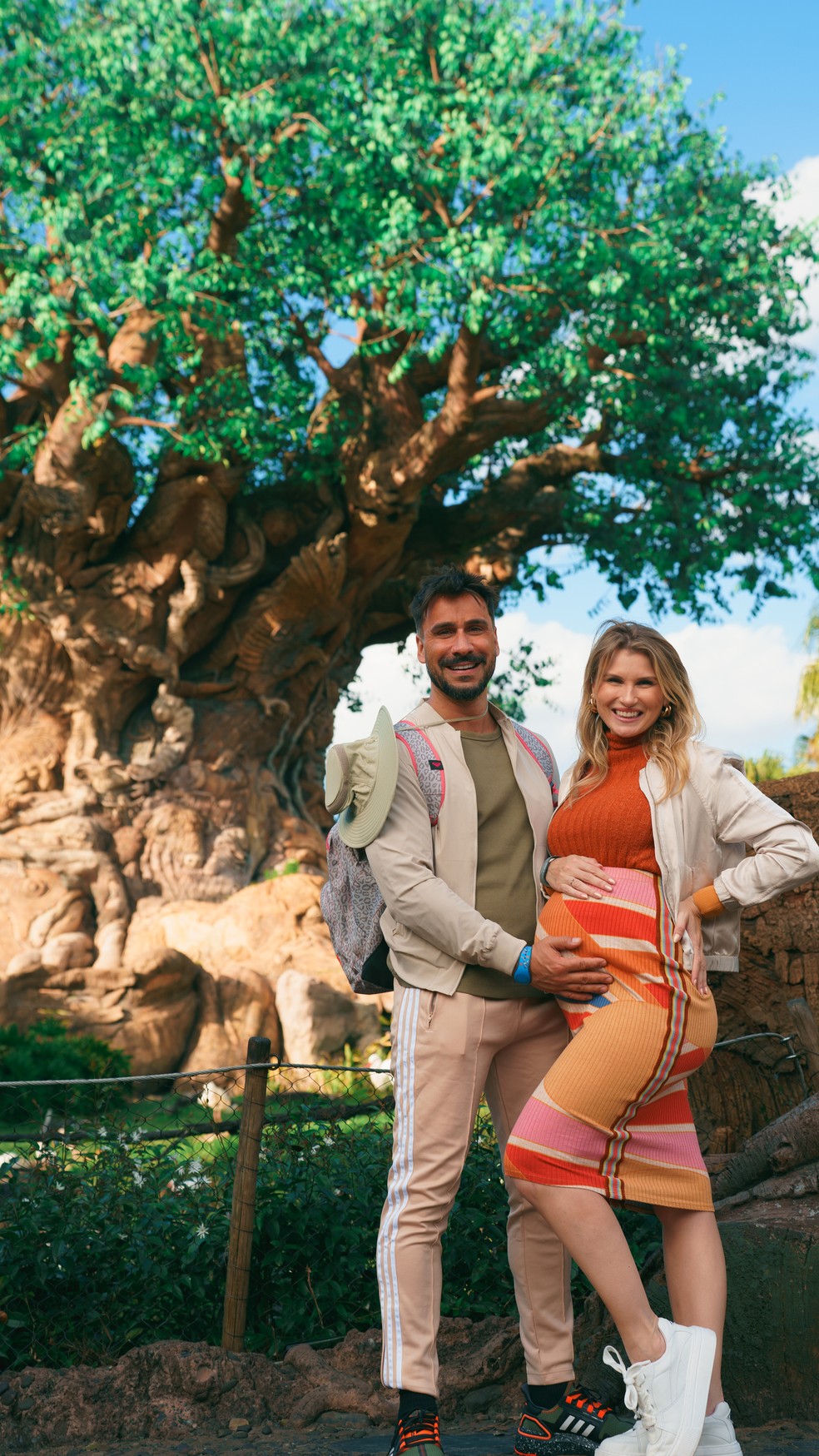 Casal aproveita gravidez da terceira filha em viagem para os parques da Disney. Na foto, os papais posam em frente ao cenário do Animal Kingdom, em Orlando — Foto: Divulgação