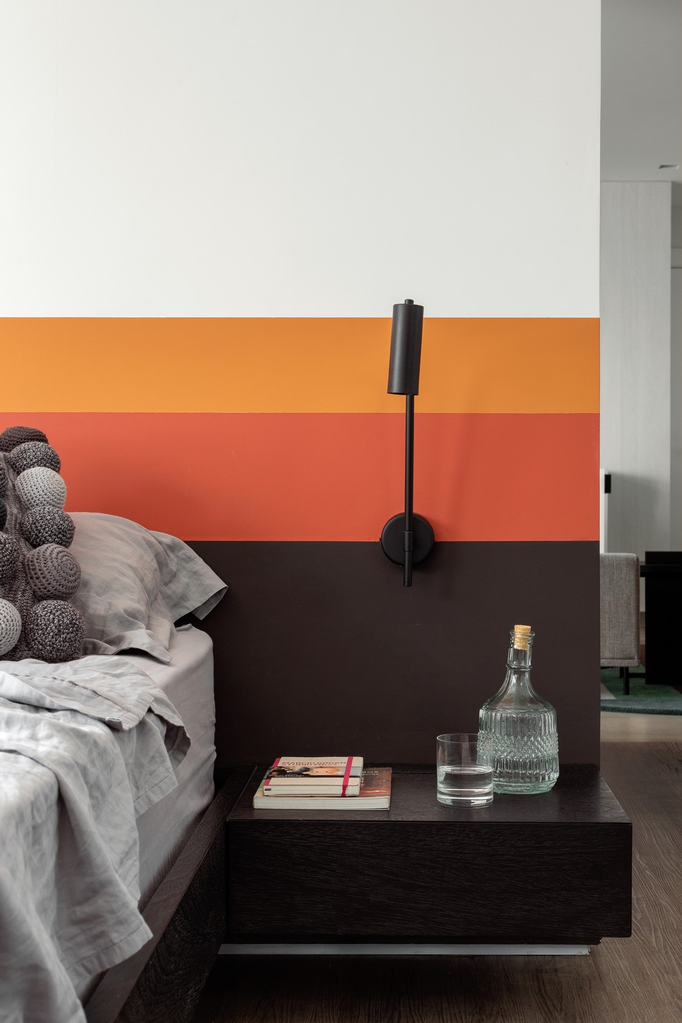 O destaque do quarto fica por conta da pintura na parede, que faz as vezes de cabeceira. Projeto do escritório Zalc Arquitetura — Foto: Carolina Lacaz / Divulgação 